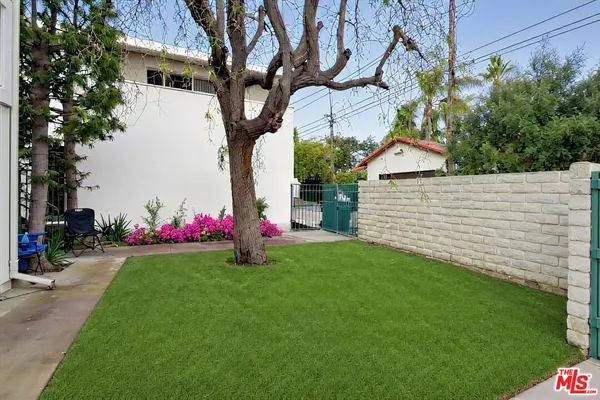 a view of a white house with a yard and a table and chair