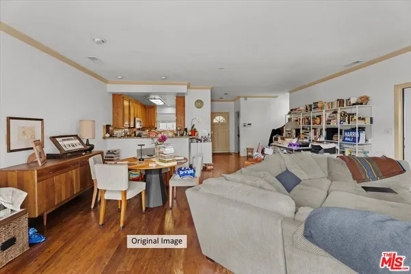 a living room with furniture and a dining table with wooden floor
