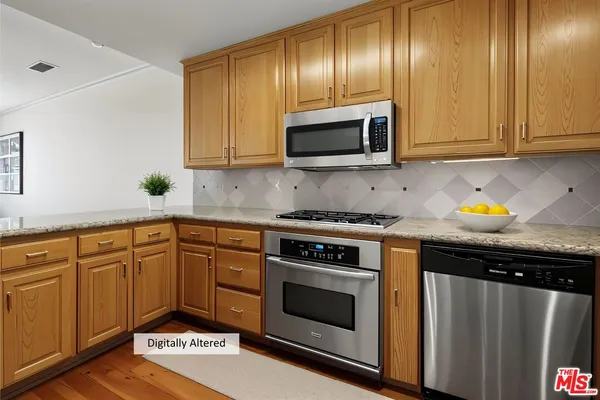 a kitchen with granite countertop stainless steel appliances a stove microwave and cabinets