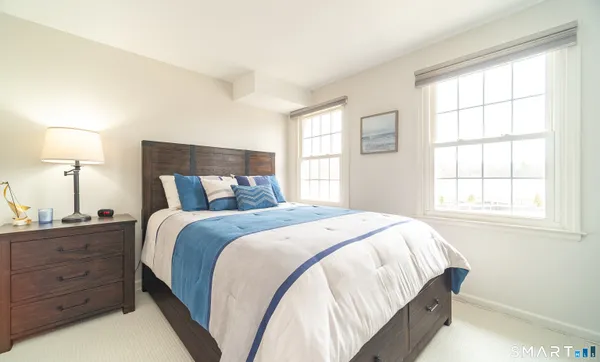 a bedroom with a bed and a lamp on dresser