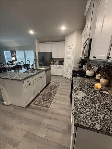 a kitchen with stainless steel appliances granite countertop a sink stove and cabinets