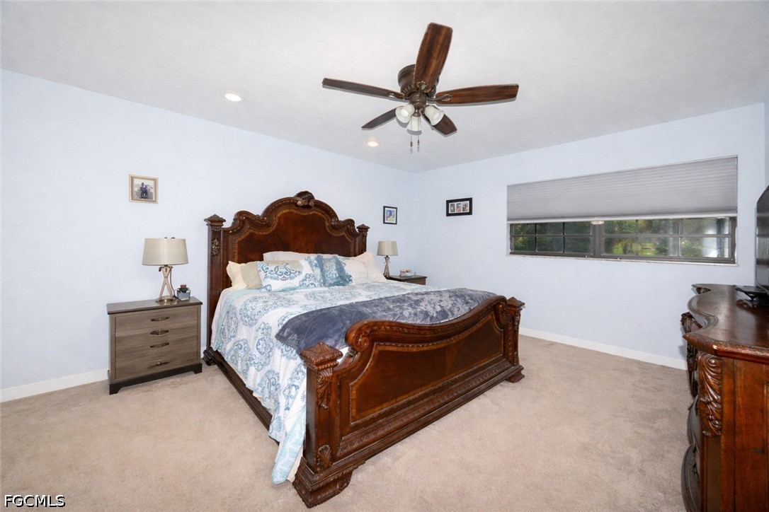15581 Old Olga Road Alva, FL 33920 - Photo 14 of 38 a bed room with a bed and a ceiling fan