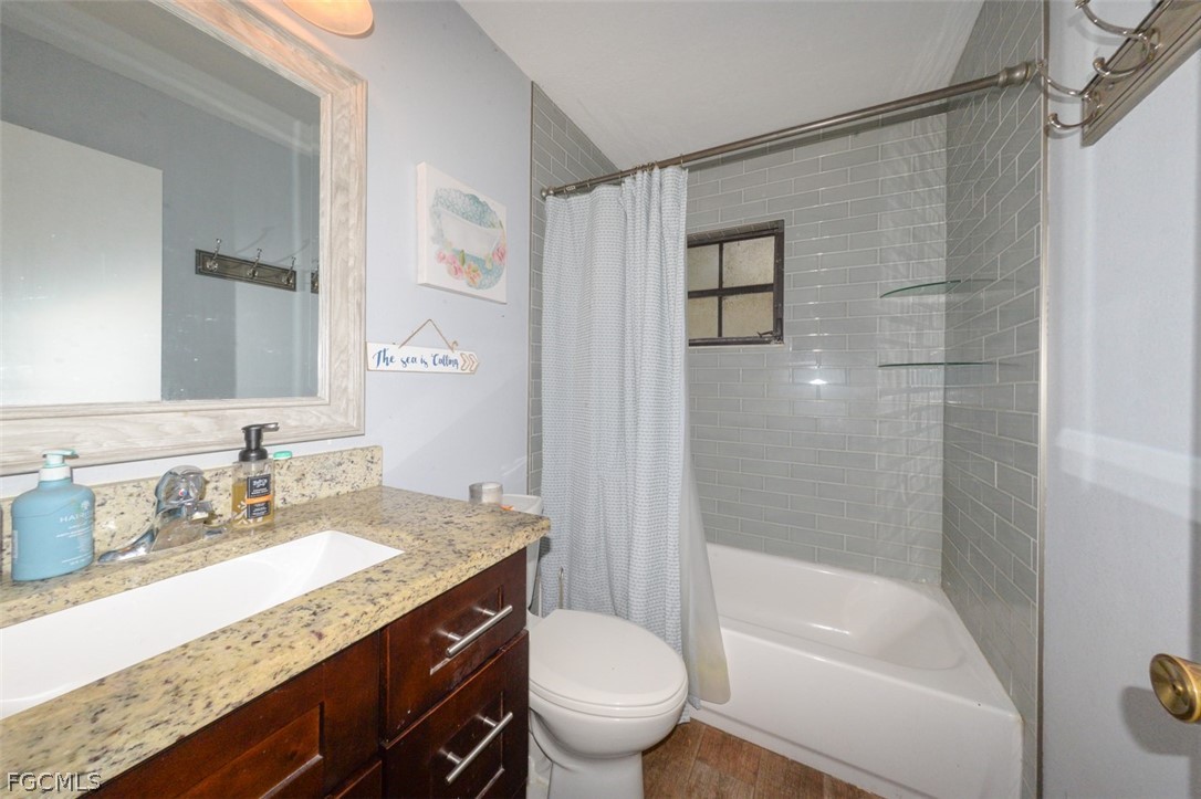 15581 Old Olga Road Alva, FL 33920 - Photo 17 of 38 a bathroom with a granite countertop sink a toilet and shower