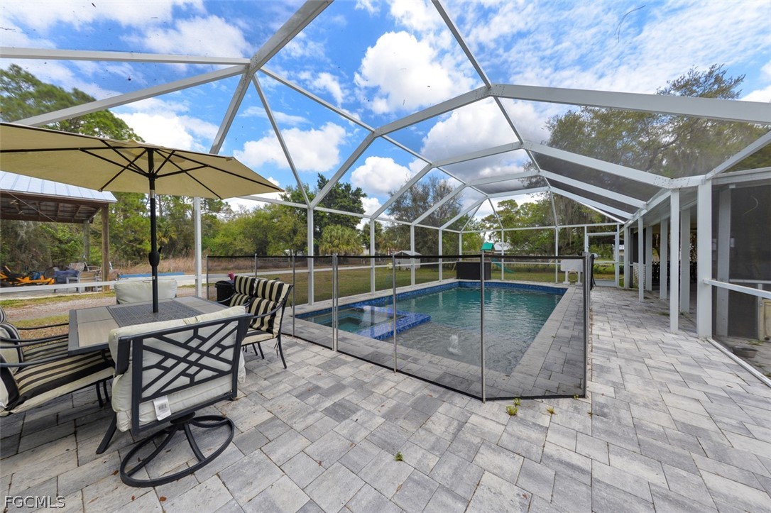 15581 Old Olga Road Alva, FL 33920 - Photo 20 of 38 a view of a roof deck with table and chairs under an umbrella