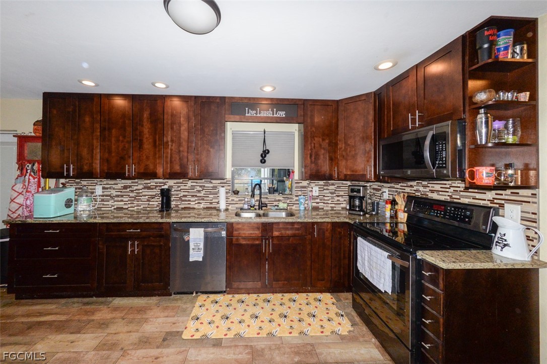 15581 Old Olga Road Alva, FL 33920 - Photo 7 of 38 a kitchen with stainless steel appliances granite countertop a sink stove and cabinets