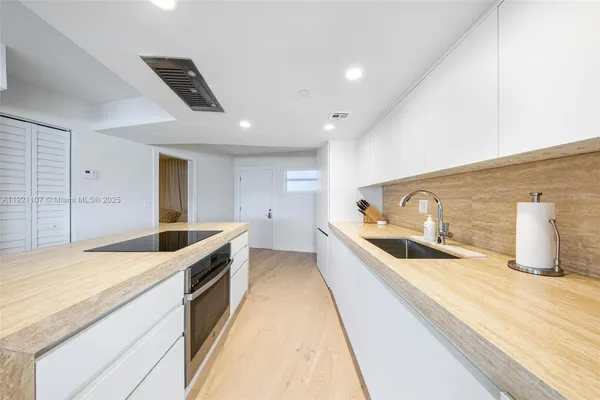 a large kitchen with stainless steel appliances kitchen island a large counter top and a sink