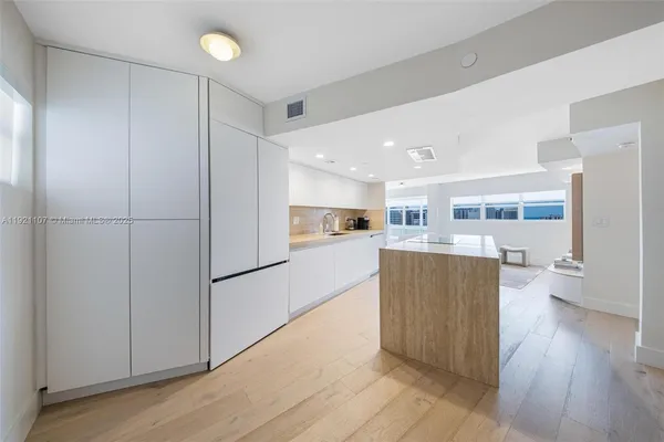 a kitchen with stainless steel appliances granite countertop a refrigerator and a stove top oven