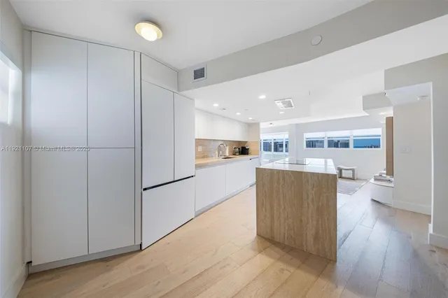 a kitchen with stainless steel appliances granite countertop a refrigerator and a stove top oven