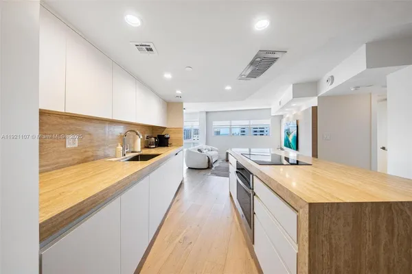 a large kitchen with kitchen island a sink a counter space and stainless steel appliances