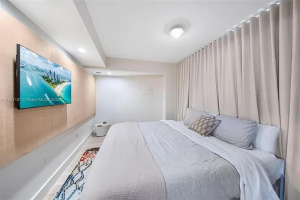 a bedroom with a bed and a flat screen tv