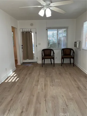 a view of a room with wooden floor and furniture