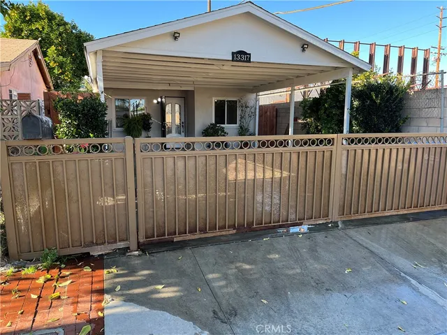 a view of a white house with iron fence