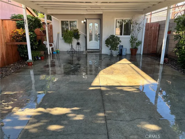 a view of a patio with table and chairs under an umbrella