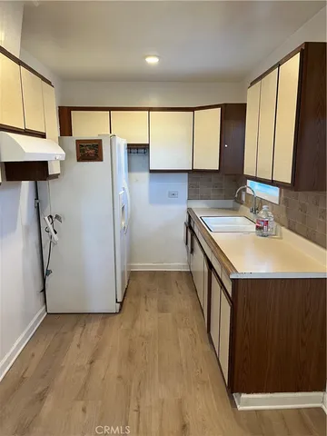a view of cabinets and wooden floor in a kitchen