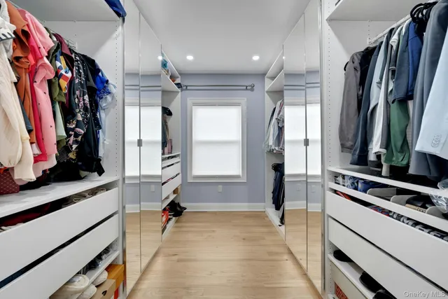 a view of walk in closet with clothes and shoes