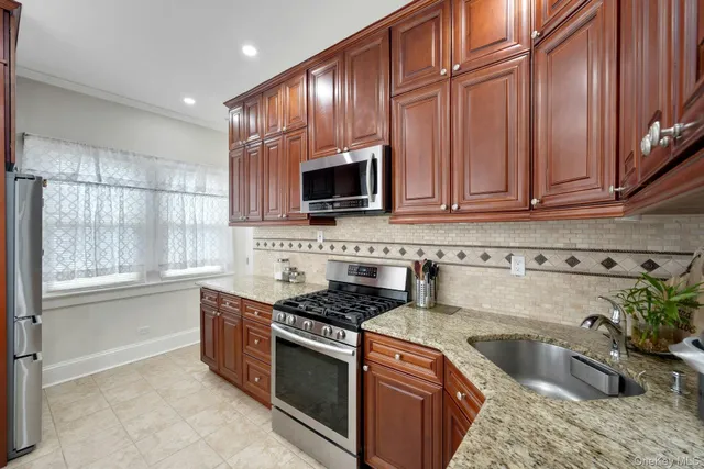 a kitchen with granite countertop cabinets stainless steel appliances and a sink