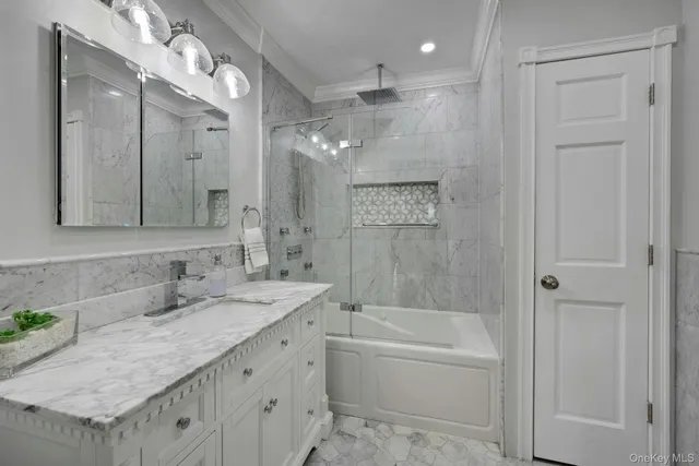 a bathroom with a granite countertop sink a mirror a bathtub and shower