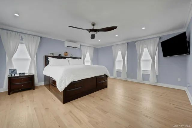 a bedroom with a bed window and a television