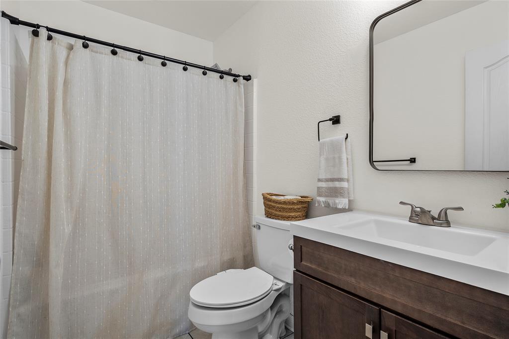 606 Powers Street Lacy-Lakeview, TX 76705 - Photo 17 of 23 a bathroom with a sink a toilet a mirror and shower curtain