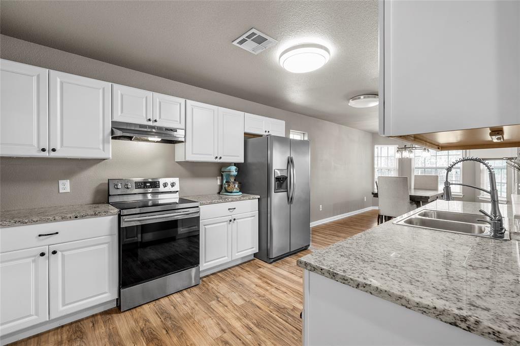 606 Powers Street Lacy-Lakeview, TX 76705 - Photo 8 of 23 a kitchen with granite countertop a sink stove and refrigerator