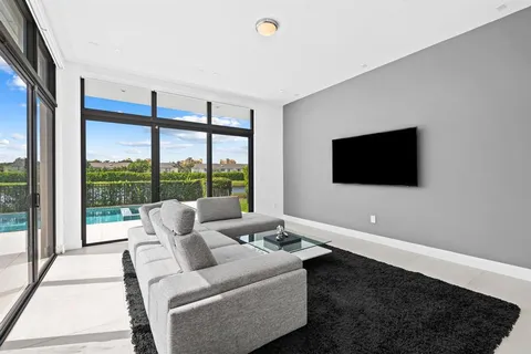 a living room with furniture tv and a floor to ceiling window