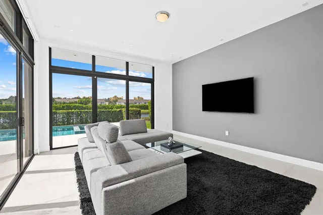 a living room with furniture tv and a floor to ceiling window