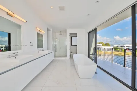a large white room with a large tub and shower