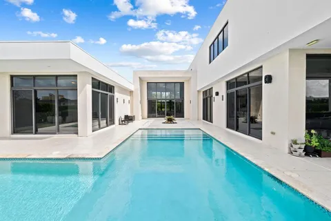 a view of an house with swimming pool and porch with furniture