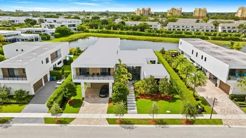 an aerial view of a house with a garden and lake view
