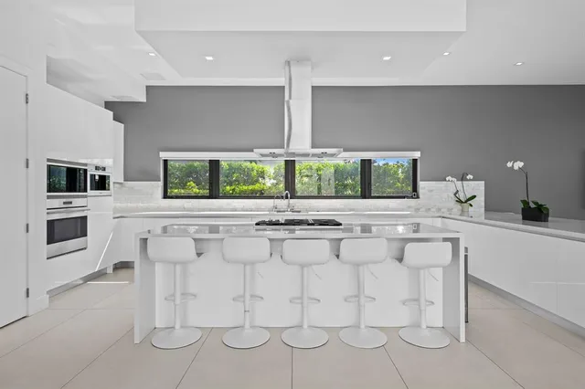 a kitchen with stainless steel appliances kitchen island granite countertop a stove and a sink