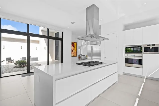 a kitchen with stainless steel appliances a stove and more cabinets