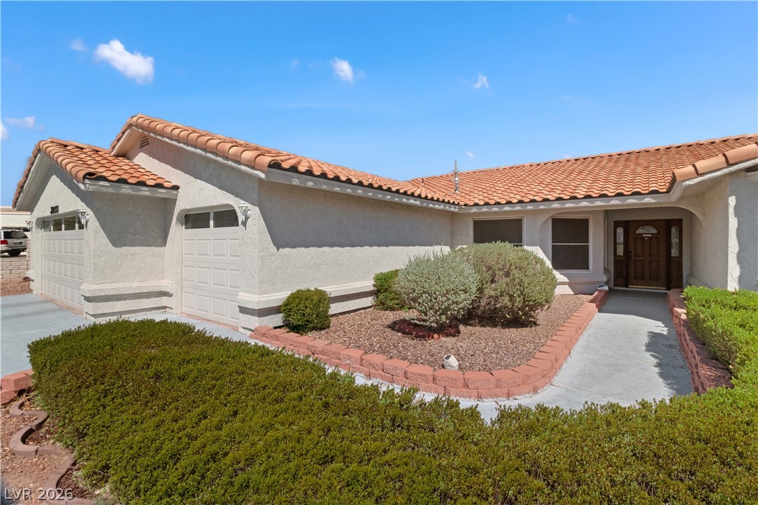 2055 Cholla Way Laughlin, NV 89029 - Photo 3 of 87 A terracotta roof crowns this well-maintained residence, featuring an attached garage and desert-friendly landscaping.