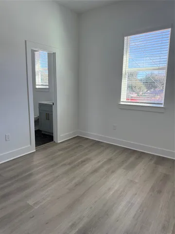 an empty room with wooden floor and a window