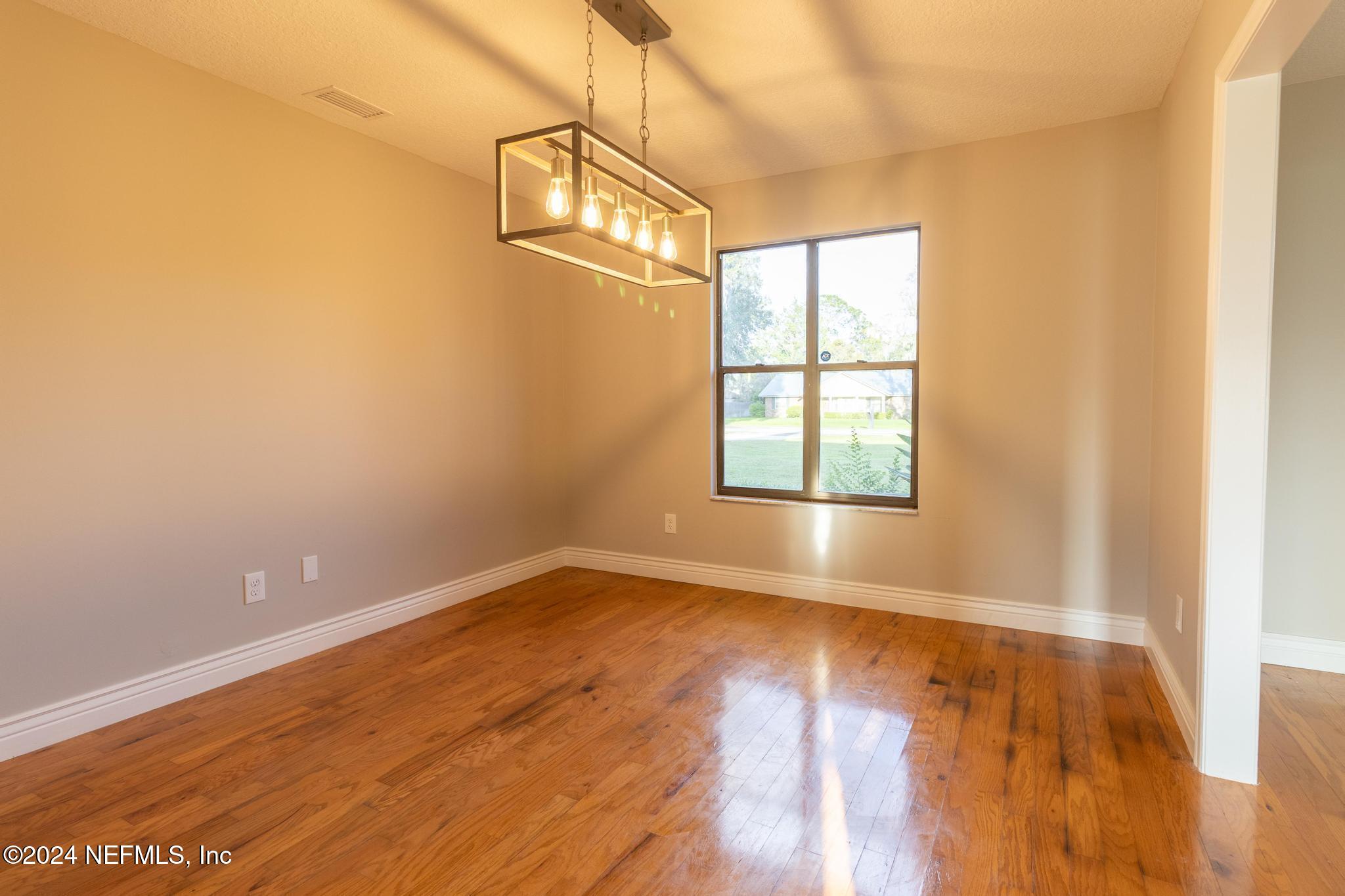 157 Timber Lane Crossing Palatka, FL 32177 - Photo 12 of 16 a view of an empty room with wooden floor and a window