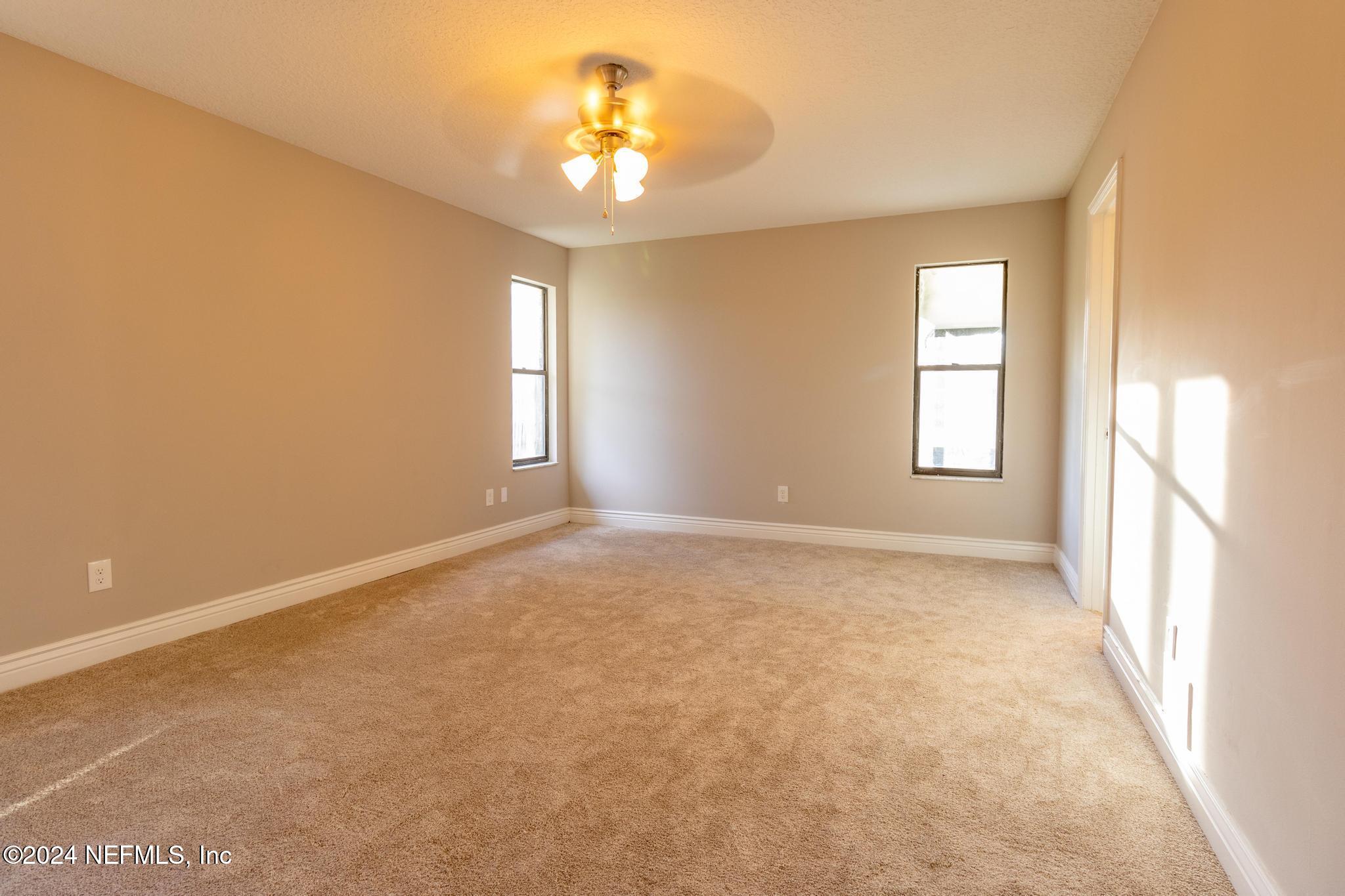 157 Timber Lane Crossing Palatka, FL 32177 - Photo 15 of 16 an empty room with windows and chandelier fan