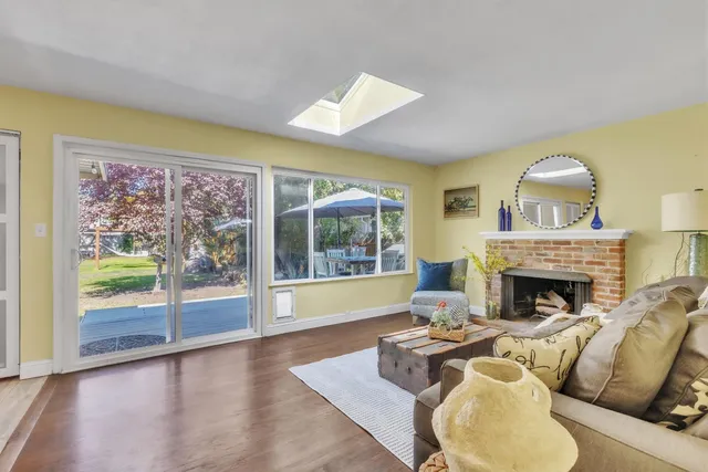a living room with furniture large window and a fireplace