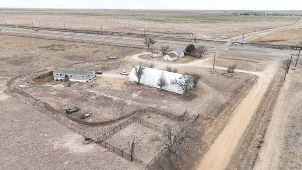 a view of a dry yard with wooden fence