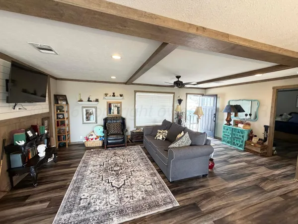 a living room with furniture a flat screen tv and a large window