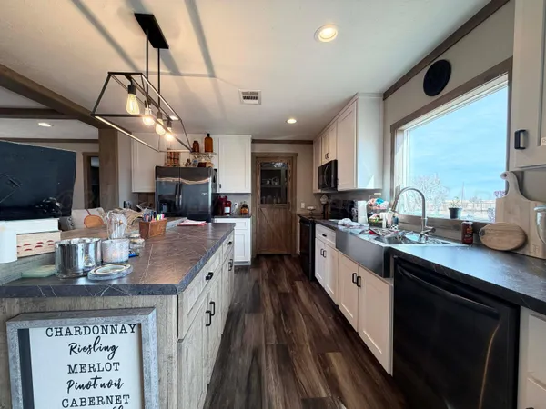 a kitchen with a sink appliances and wooden floor