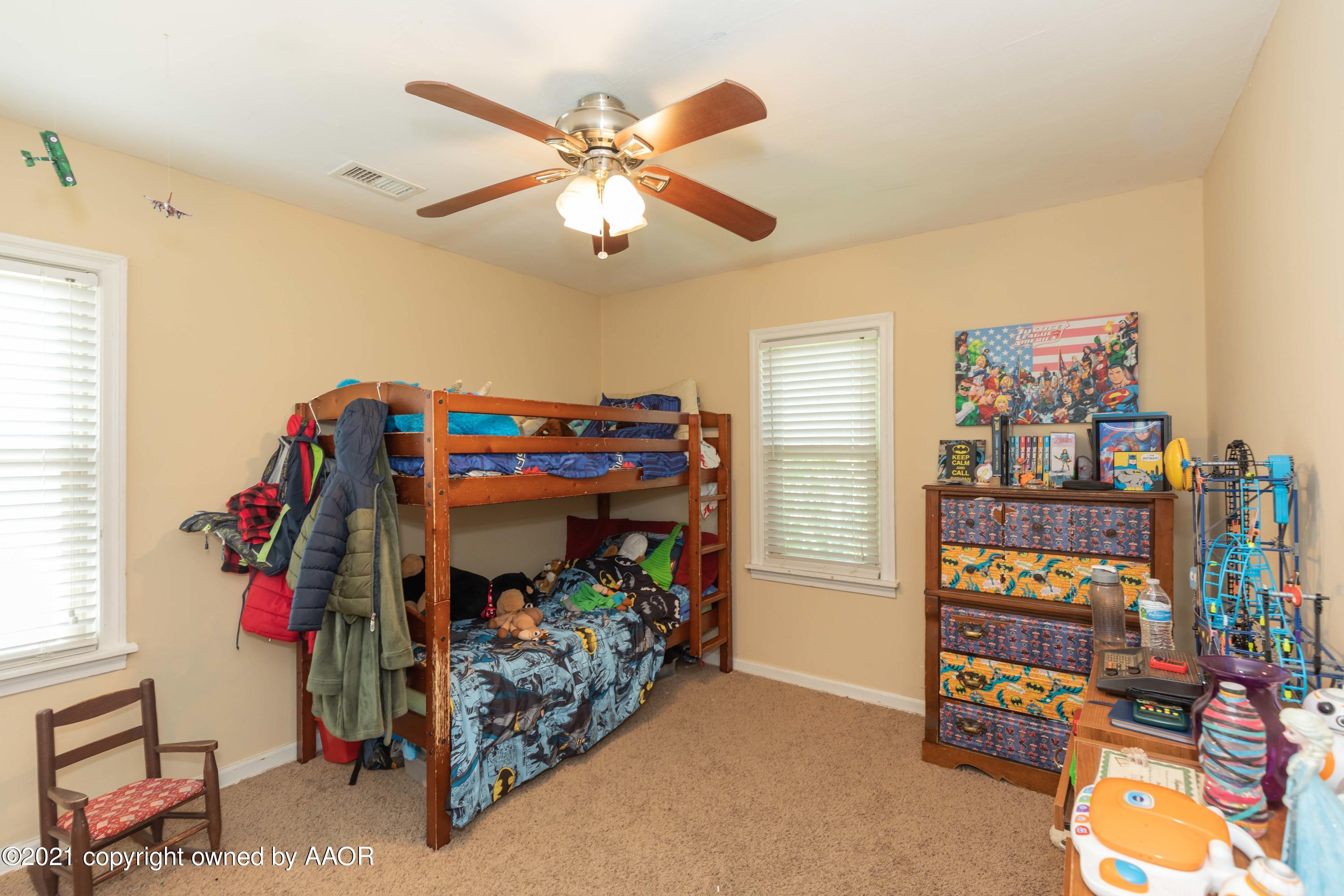 3817 South Hughes Street Amarillo, TX 79110 - Photo 14 of 36 a bed room with a bed and a baby bed
