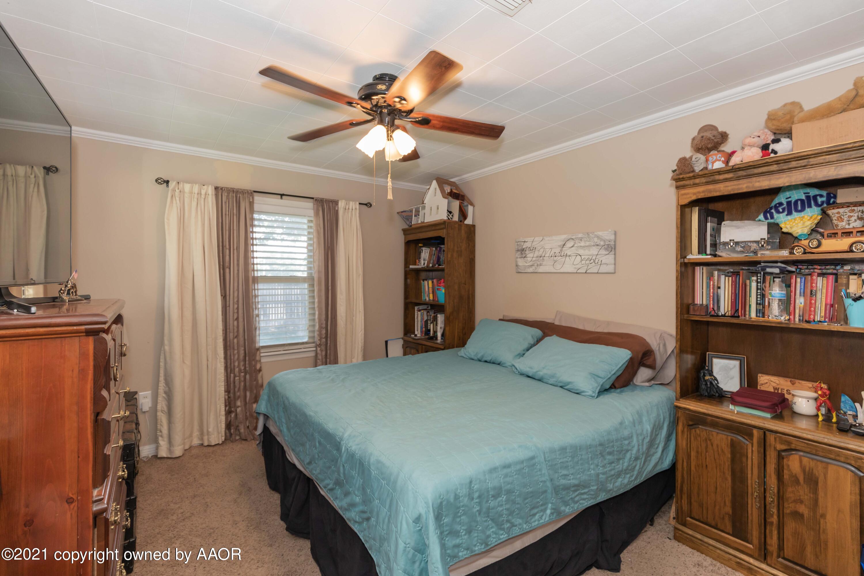 3817 South Hughes Street Amarillo, TX 79110 - Photo 25 of 36 a bedroom with a bed and a book shelf