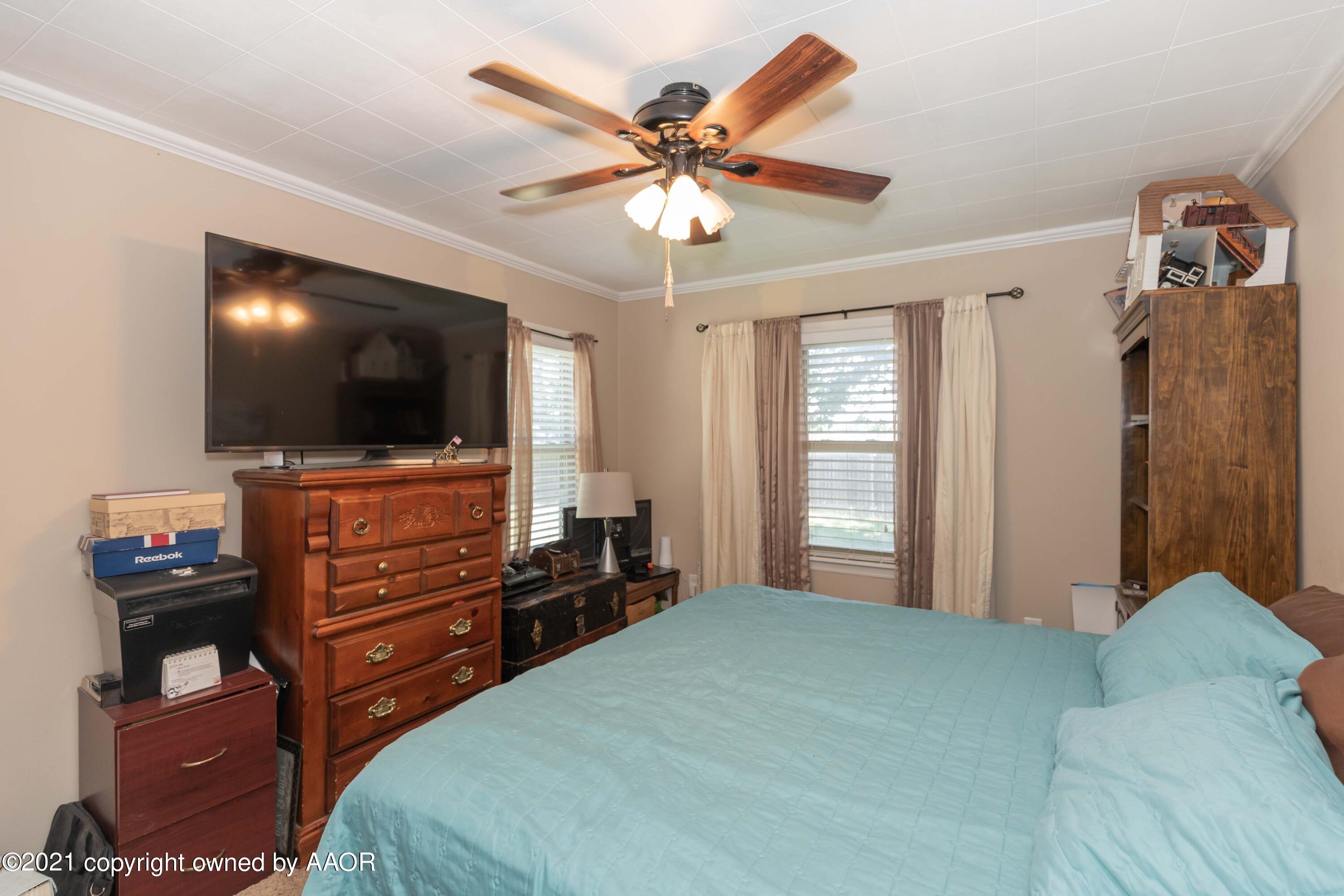 3817 South Hughes Street Amarillo, TX 79110 - Photo 26 of 36 a bedroom with a bed and a flat screen tv
