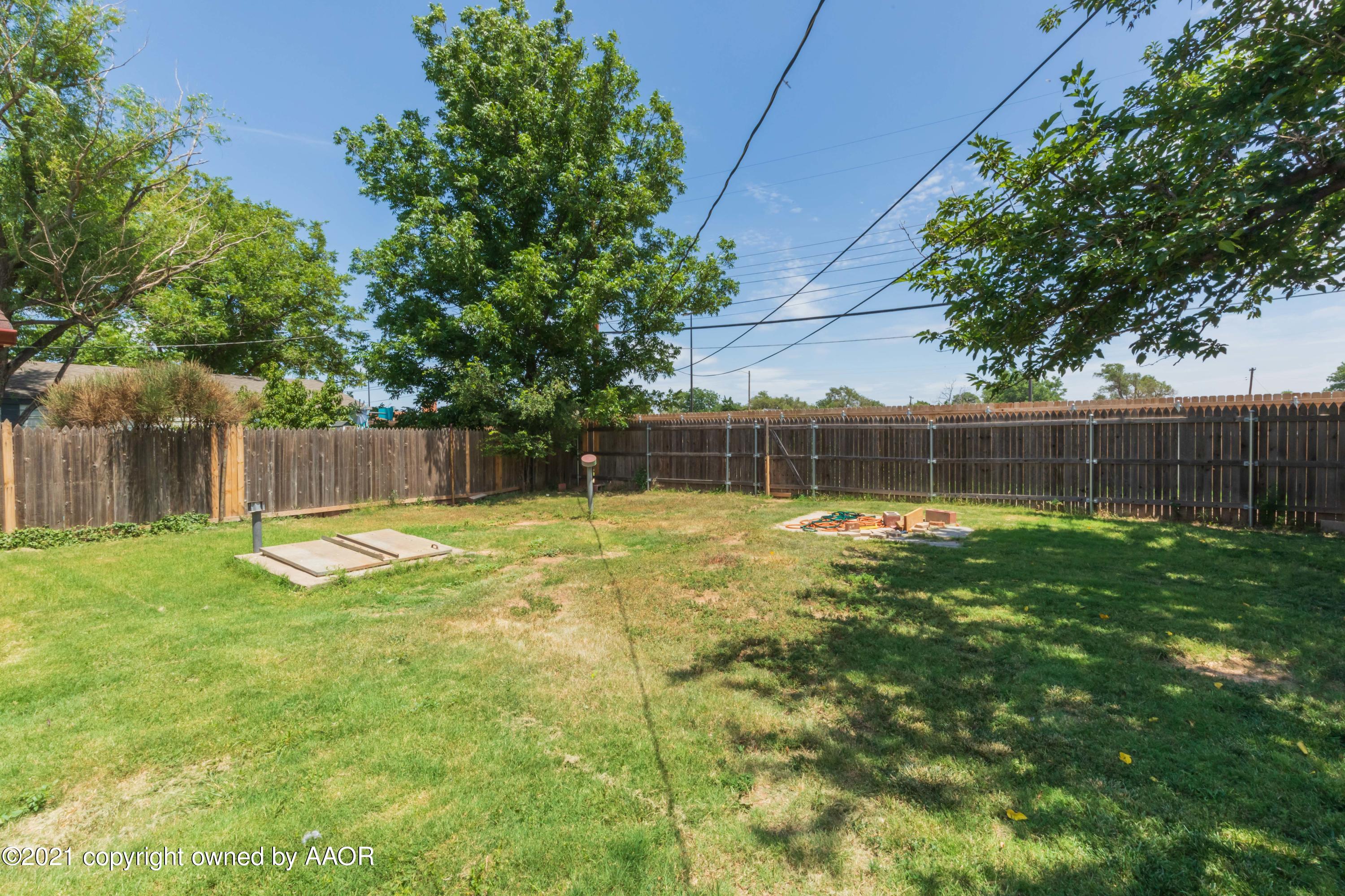 3817 South Hughes Street Amarillo, TX 79110 - Photo 36 of 36 a view of a backyard with a tree and wooden fence