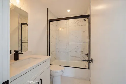 a bathroom with a shower a toilet and a sink