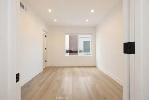 a view of a big room with wooden floor and windows