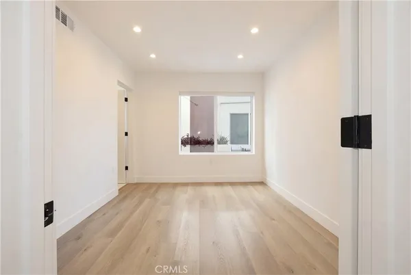 a view of a big room with wooden floor and windows