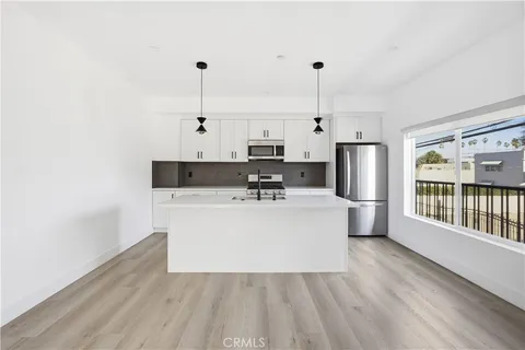 a view of a kitchen with stainless steel appliances granite countertop a stove top oven