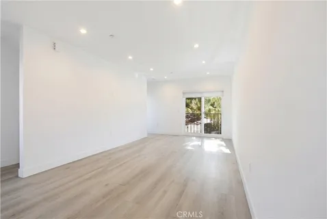 a view of a big room with wooden floor and windows