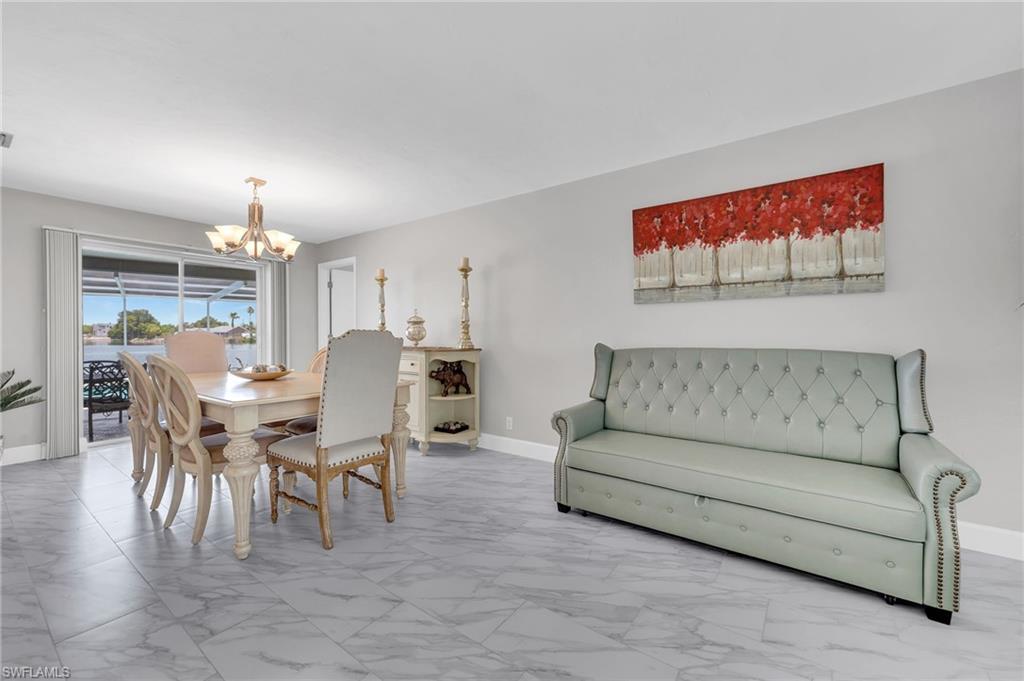 3065 50th Lane Southwest Naples, FL 34116 - Photo 5 of 31 a living room with furniture dining table and a chandelier