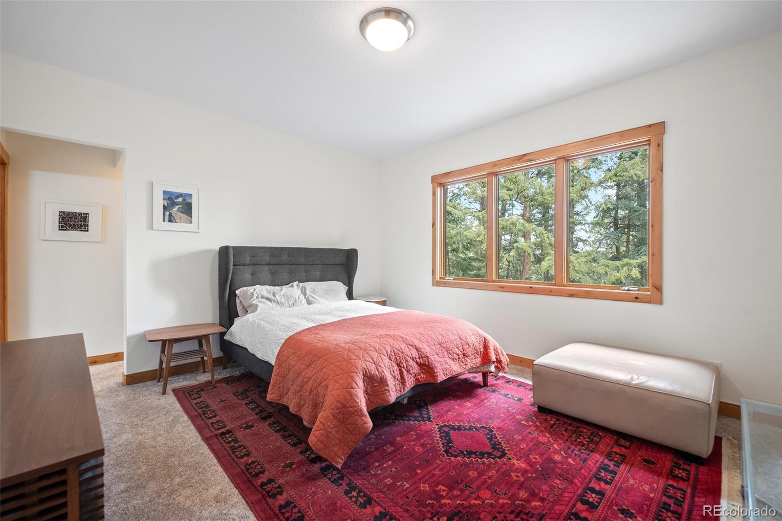 27711 Moffat Road Evergreen, CO 80439 - Photo 14 of 30 a bedroom with a bed and wooden floor